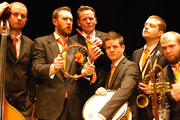 Alex Horne Presents The Horne Section. Image shows from L to R: Bass (Will Collier), Alex Horne, Keyboards and Piano (Joe Stilgoe), Drums (Ben Reynolds), Saxophone (Mark Brown), Trumpet (Joe Auckland). Copyright: BBC