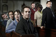 Rev.. Image shows from L to R: Colin Lambert (Steve Evets), Ellie Pattman (Lucy Liemann), Alex Smallbone (Olivia Colman), Rev Adam Smallbone (Tom Hollander), Nigel McCall (Miles Jupp), Adoha Onyeka (Ellen Thomas), Archdeacon Robert (Simon McBurney). Copyright: Big Talk Productions