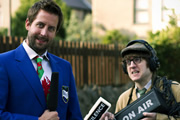 Social Club FM. Image shows from L to R: Mr Chairman (Chris Corcoran), Rex Jones (Elis James). Copyright: Zipline Creative