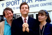 The Brittas Empire. Image shows from L to R: Colin Wetherby (Mike Burns), Gordon Brittas (Chris Barrie), Laura Lancing (Julia St. John). Copyright: BBC