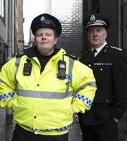 Scot Squad. Image shows from L to R: Officer/Acting Sgt. Ken Beattie (James Allenby-Kirk), Chief Commissioner Cameron Miekelson (Jack Docherty). Copyright: The Comedy Unit