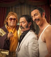 SunTrap. Image shows from L to R: Elton Juan (Lee Boardman), Senor Big (Keith Allen), Frederico Mercury (Paul Kaye). Copyright: Happy Tramp Productions