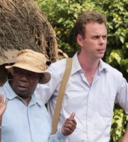 Taking The Flak. Image shows from L to R: Goroi (David Mulwa), Harry Chambers (Bruce Mackinnon). Copyright: BBC