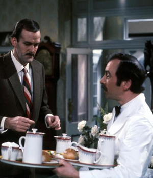 Fawlty Towers. Image shows from L to R: Basil Fawlty (John Cleese), Manuel (Andrew Sachs). Copyright: BBC