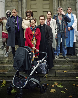 Rev.. Image shows from L to R: Mick (Jimmy Akingbola), Archdeacon Robert (Simon McBurney), Adoha Onyeka (Ellen Thomas), Alex Smallbone (Olivia Colman), Rev Adam Smallbone (Tom Hollander), Ellie Pattman (Lucy Liemann), Colin Lambert (Steve Evets), Nigel McCall (Miles Jupp). Copyright: Big Talk Productions