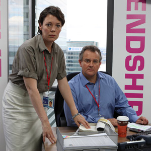 Twenty Twelve. Image shows from L to R: Sally Owen (Olivia Colman), Ian Fletcher (Hugh Bonneville). Copyright: BBC