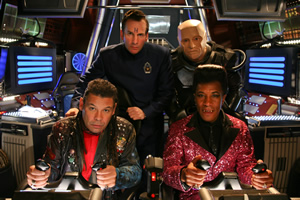 Red Dwarf. Image shows from L to R: Lister (Craig Charles), Rimmer (Chris Barrie), Kryten (Robert Llewellyn), Cat (Danny John-Jules). Copyright: UKTV