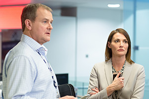 W1A. Image shows left to right: Ian Fletcher (Hugh Bonneville), Anna Rampton (Sarah Parish)