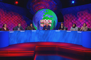 Mock The Week. Image shows from L to R: Laura Lexx, Hugh Dennis, Rhys James, Dara O Briain, Glenn Moore, Sukh Ojla, Ed Byrne. Copyright: Angst Productions