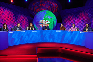 Mock The Week. Image shows from L to R: Angela Barnes, Hugh Dennis, Alasdair Beckett-King, Dara O Briain, Rhys James, Maisie Adam, Eshaan Akbar. Copyright: Angst Productions