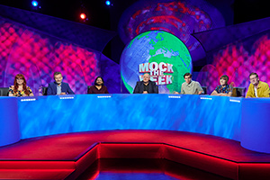 Mock The Week. Image shows from L to R: Angela Barnes, Hugh Dennis, Ahir Shah, Dara O Briain, Rhys James, Maisie Adam, Robin Morgan. Copyright: Angst Productions