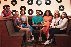 The Other One. Image shows from L to R: Marcus (Amit Shah), Cathy (Ellie White), Tess (Rebecca Front), Callum (Christopher Jeffers), Angela (Michele Austin), Marilyn (Siobhan Finneran), Cat (Lauren Socha)