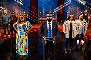 Sorry, I Didn't Know. Image shows from L to R: Miles Jupp, Paul Chowdhry, Chizzy Akudolu, Jimmy Akingbola, Judi Love, Sukh Ojla, Tom Moutchi. Copyright: Triforce Productions