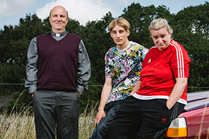 This Country. Image shows from L to R: Reverend Francis Seaton (Paul Chahidi), Lee 'Kurtan' Mucklowe (Charlie Cooper), Kerry Mucklowe (Daisy May Cooper)