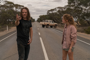 Upright. Image shows from L to R: Lucky Flynn (Tim Minchin), Meg Adams (Milly Alcock)