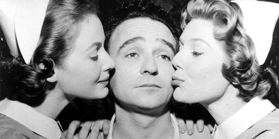 Bernie Bishop (Kenneth Connor) being kissed by two nurses.. Credit: STUDIOCANAL