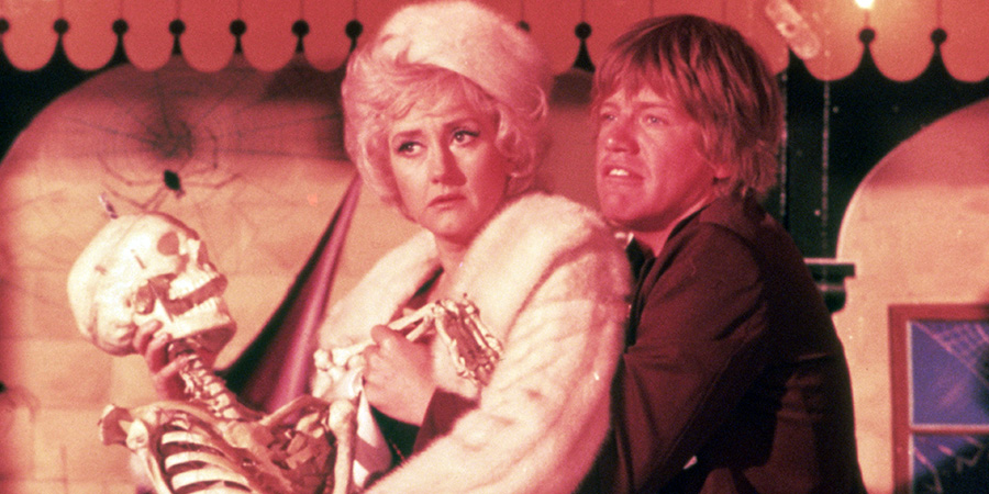 Confessions From A Holiday Camp. Image shows left to right: Antonia Whitemonk (Liz Fraser), Timothy Lea (Robin Askwith). Credit: Columbia Pictures