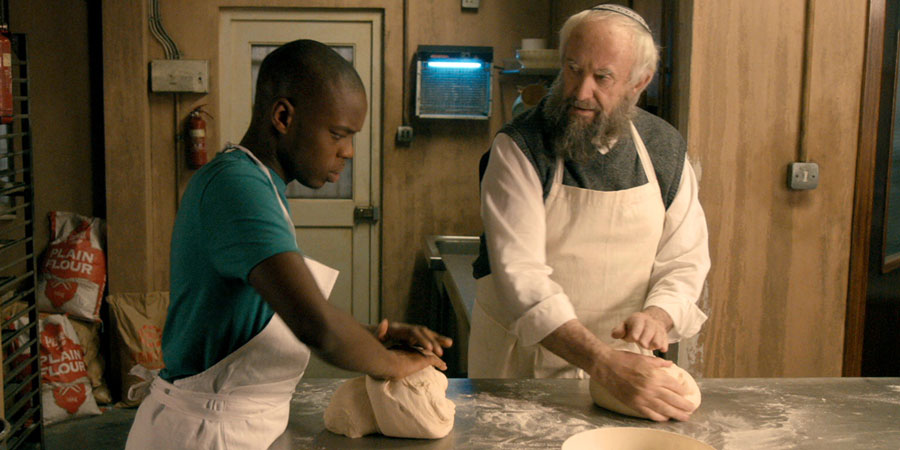 Dough. Image shows from L to R: Ayyash (Jerome Holder), Nat Dayan (Jonathan Pryce)