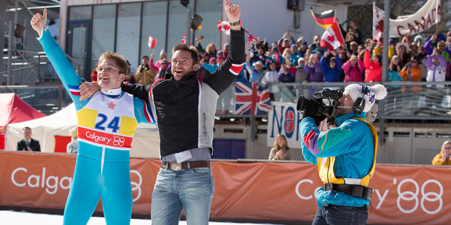 Eddie The Eagle. Image shows from L to R: Michael 'Eddie' Edwards (Taron Egerton), Bronson Peary (Hugh Jackman)