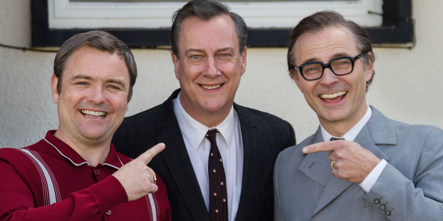 Eric, Ernie And Me. Image shows from L to R: Eric Morecambe (Mark Bonnar), Eddie Braben (Stephen Tompkinson), Ernie Wise (Neil Maskell). Copyright: Objective Productions