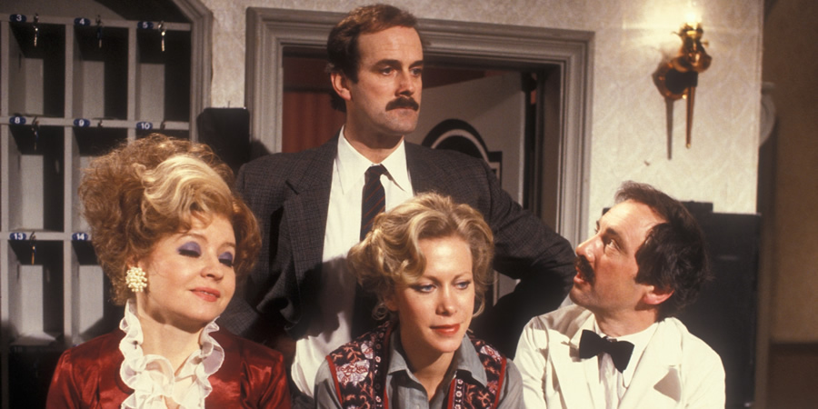 Fawlty Towers. Image shows from L to R: Sybil Fawlty (Prunella Scales), Basil Fawlty (John Cleese), Polly (Connie Booth), Manuel (Andrew Sachs). Copyright: BBC