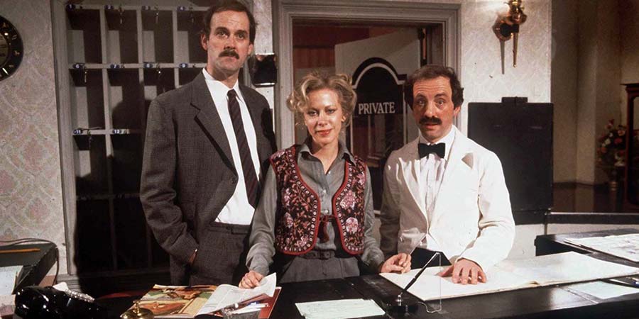 Fawlty Towers. Image shows from L to R: Basil Fawlty (John Cleese), Polly (Connie Booth), Manuel (Andrew Sachs). Copyright: BBC