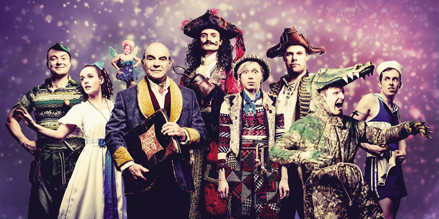 Peter Pan Goes Wrong. Image shows from L to R: Jonathan (Peter Pan) (Greg Tannahill), Sandra (Wendy) (Charlie Russell), Annie (Mrs Darling / Lisa / Tinkerbell) (Nancy Zamit), The Narrator (David Suchet), Chris (Hook) (Henry Shields), Lucy (Tootles) (Ellie Morris), Robert (Starkey) (Henry Lewis), Max (Crocodile) (Dave Hearn), Dennis (Smee) (Jonathan Sayer). Copyright: Idil Sukan