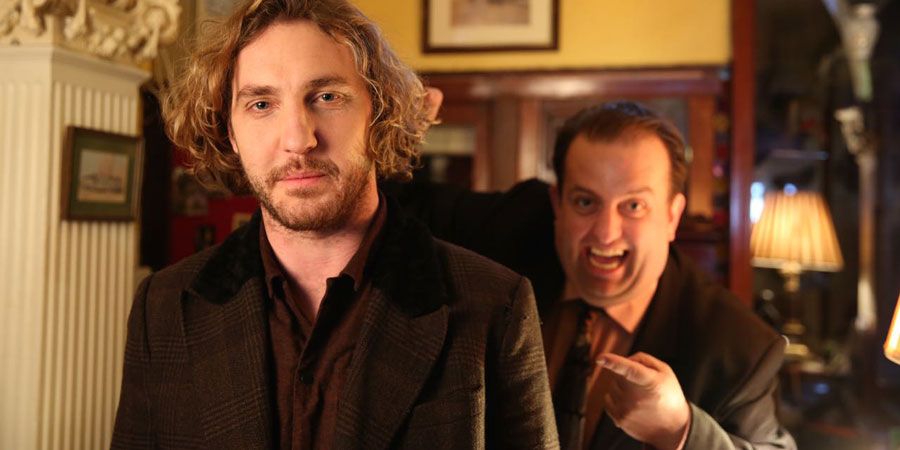 Seann Walsh In Ireland. Image shows from L to R: Robin (Seann Walsh), Hotel Receptionist (Karl Spain). Copyright: Baby Cow Productions / Sky