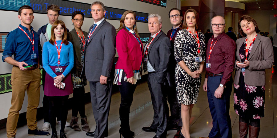 W1A. Image shows from L to R: Jack Patterson (Jonathan Bailey), Will Humphries (Hugh Skinner), Izzy Gould (Ophelia Lovibond), Lucy Freeman (Nina Sosanya), Ian Fletcher (Hugh Bonneville), Siobhan Sharpe (Jessica Hynes), Neil Reid (David Westhead), David Wilkes (Rufus Jones), Anna Rampton (Sarah Parish), Simon Harwood (Jason Watkins), Tracey Pritchard (Monica Dolan). Copyright: BBC