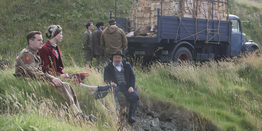 Whisky Galore!. Image shows from L to R: Sergeant Odd (Sean Biggerstaff), Peggy Macroon (Naomi Battrick), Joseph Macroon (Gregor Fisher). Copyright: Whisky Galore Movie Plc