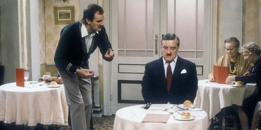 Fawlty Towers. Image shows from L to R: Basil Fawlty (John Cleese), Mr. Hutchinson (Bernard Cribbins), Miss Gatsby (Renee Roberts), Miss Tibbs (Gilly Flower). Copyright: BBC