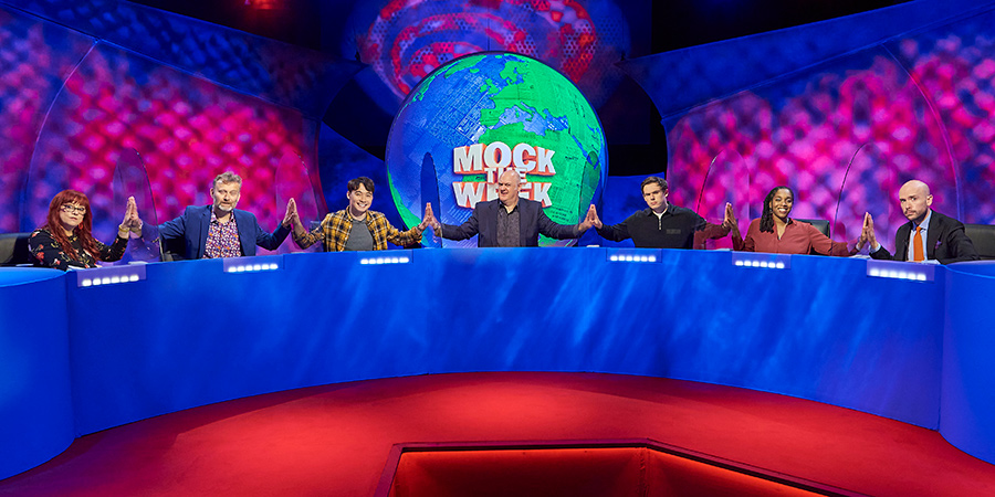 Mock The Week. Image shows from L to R: Angela Barnes, Hugh Dennis, Nigel Ng, Dara O Briain, Rhys James, Athena Kugblenu, Tom Allen. Copyright: Angst Productions