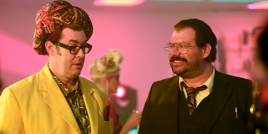 Murder In Successville. Image shows from L to R: Richard Osman, DI Sleet (Tom Davis). Copyright: Tiger Aspect Productions