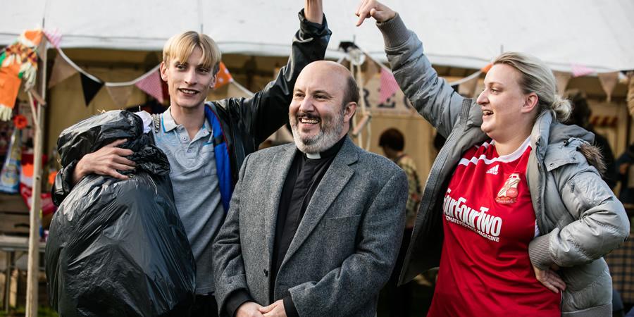 This Country. Image shows from L to R: Lee 'Kurtan' Mucklowe (Charlie Cooper), Reverend Francis Seaton (Paul Chahidi), Kerry Mucklowe (Daisy May Cooper). Copyright: BBC