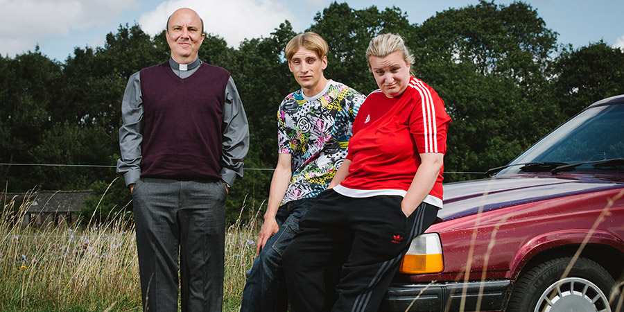 This Country. Image shows from L to R: Reverend Francis Seaton (Paul Chahidi), Lee 'Kurtan' Mucklowe (Charlie Cooper), Kerry Mucklowe (Daisy May Cooper)