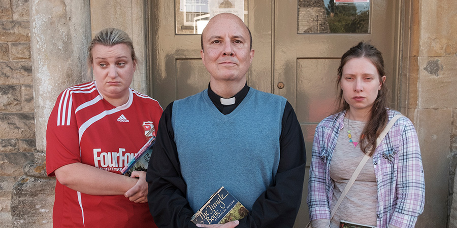 This Country. Image shows from L to R: Kerry Mucklowe (Daisy May Cooper), Reverend Francis Seaton (Paul Chahidi), Kayleigh Hudson (Celeste Dring)