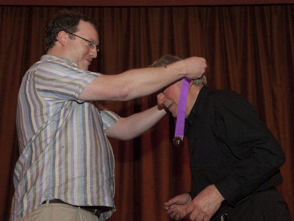 Terry Jones receiving the Bath Plug award. Image shows from L to R: Nick Steel, Terry Jones