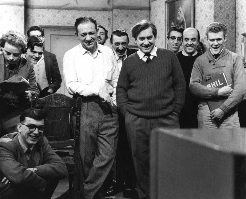 Cast and crew members of Hancock's Half Hour, including Sidney James, Mario Fabrizi and Tony Hancock, pictured on set. Credit: National Portrait Gallery