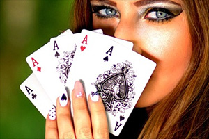 A woman holding five aces to her facce