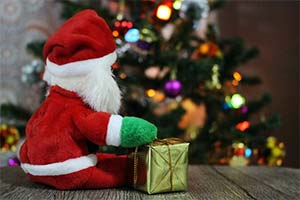 A Father Christmas toy in front of a Christmas tree