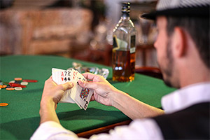 Man sat at a gambling table with cards and chips