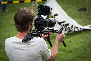 Man using a camera mounted on his shoulder