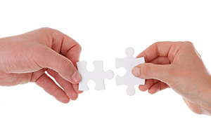 Two hands holding jigsaw pieces