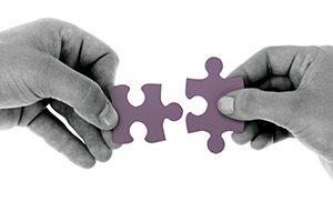 Two hands holding jigsaw pieces