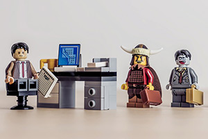 Lego characters lining up by a desk