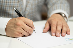 Person signing a piece of paper