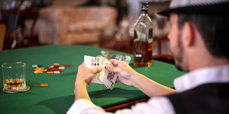 Man sat at a gambling table with cards and chips