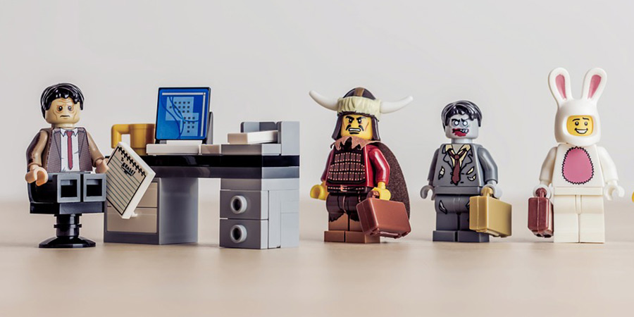 Lego characters lining up by a desk