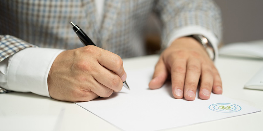 Person signing a piece of paper