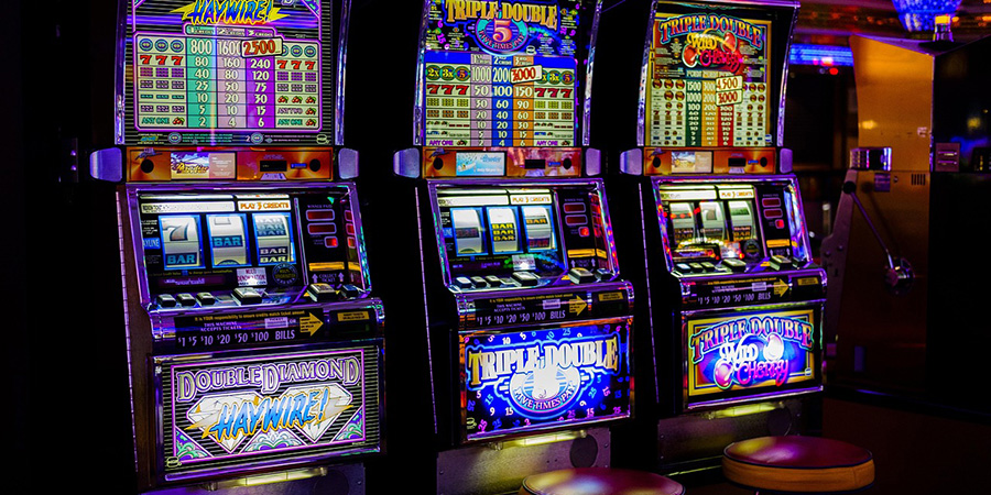 A line-up of three casino slot machines A line-up of three casino slot machines